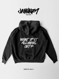 Black hoodie laid flat on a white background. Back of the hoodie features the phrase ‘What if it all works out?’ in light gray handwritten-style lettering. Text above the image reads ‘January’ and ‘Ships by Jan 16.’
