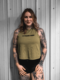 Woman wearing a green tank top with 'Pseudo Force' logo against a gray wall